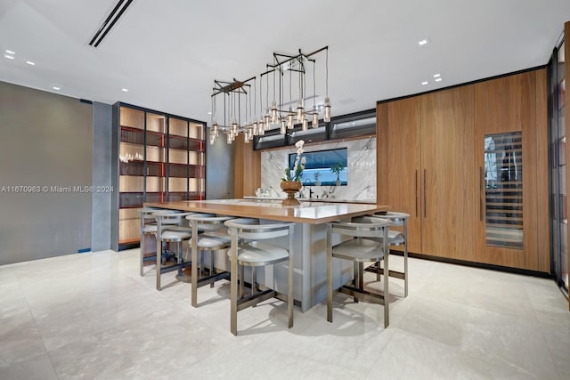 kitchen featuring tasteful backsplash, wood walls, a kitchen bar, and hanging light fixtures