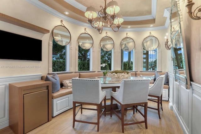 dining space featuring ornamental molding, a notable chandelier, light wood finished floors, and plenty of natural light