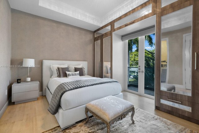 bedroom with wood finished floors, french doors, access to outside, and baseboards