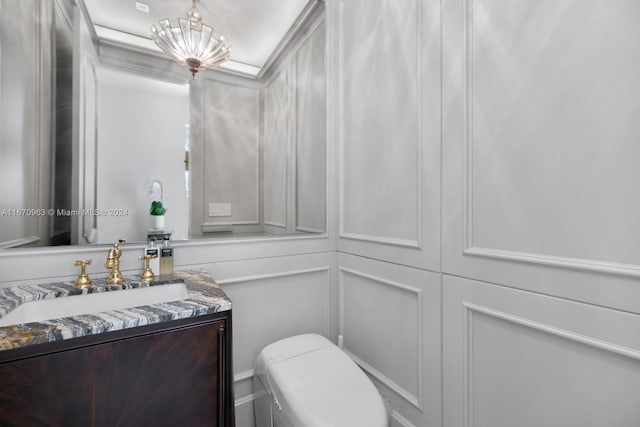 bathroom with vanity, a notable chandelier, and toilet