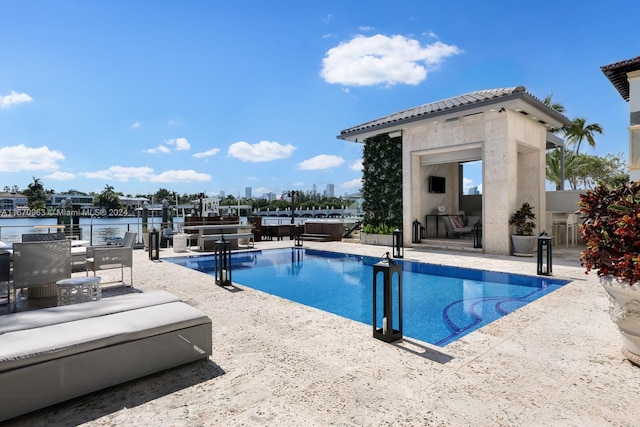 pool featuring a boat dock, a water view, a patio, and boat lift