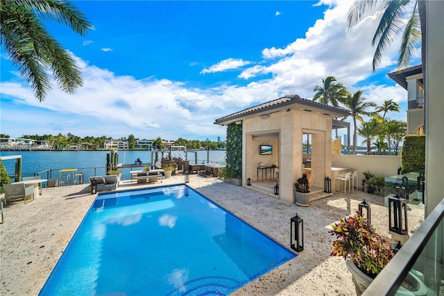view of swimming pool featuring an outdoor structure, a boat dock, boat lift, a fenced in pool, and a water view
