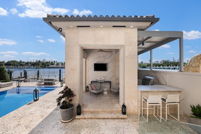 view of patio featuring fence, an outdoor pool, outdoor dry bar, and a grill