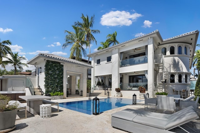 exterior space featuring ceiling fan, a patio area, a hot tub, and stairs