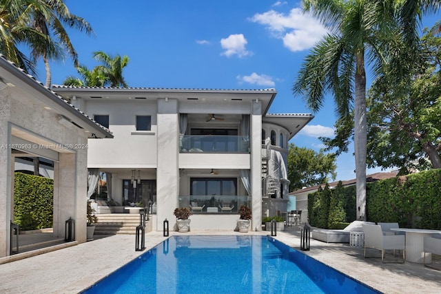 back of property featuring a patio, a ceiling fan, a fenced in pool, and stucco siding