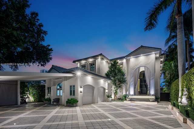 mediterranean / spanish house featuring stucco siding, driveway, and an attached garage