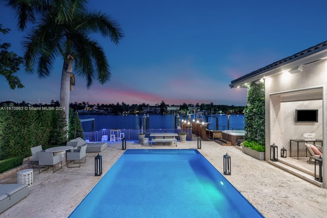 outdoor pool featuring a hot tub and a patio area