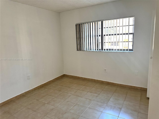 tiled spare room featuring a textured ceiling