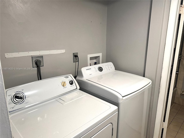 clothes washing area with tile patterned flooring and separate washer and dryer