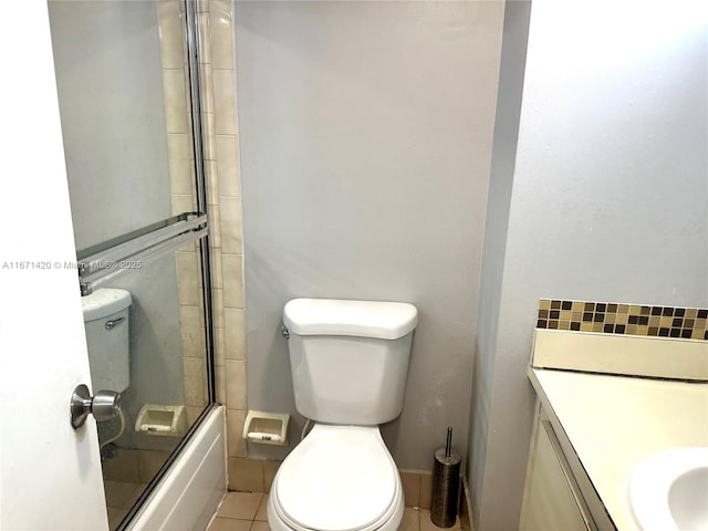 full bathroom with tile patterned flooring, toilet, vanity, and combined bath / shower with glass door