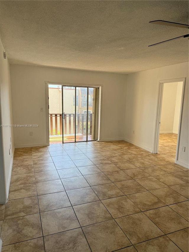 unfurnished room with a textured ceiling and light tile patterned flooring