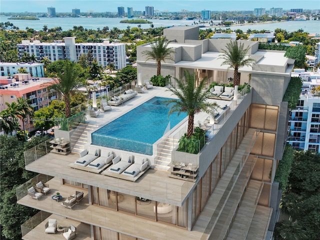 view of swimming pool featuring a patio and a water view