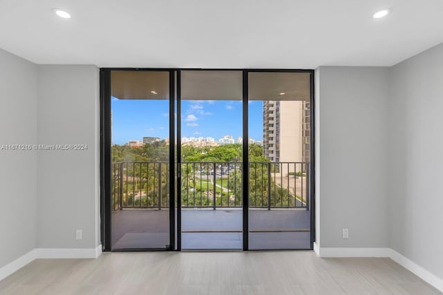 unfurnished room featuring light wood-type flooring and floor to ceiling windows