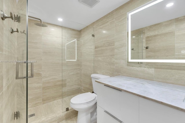 bathroom with walk in shower, tile walls, vanity, and toilet