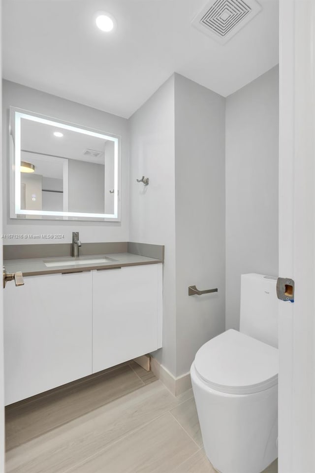 bathroom featuring vanity, hardwood / wood-style flooring, and toilet