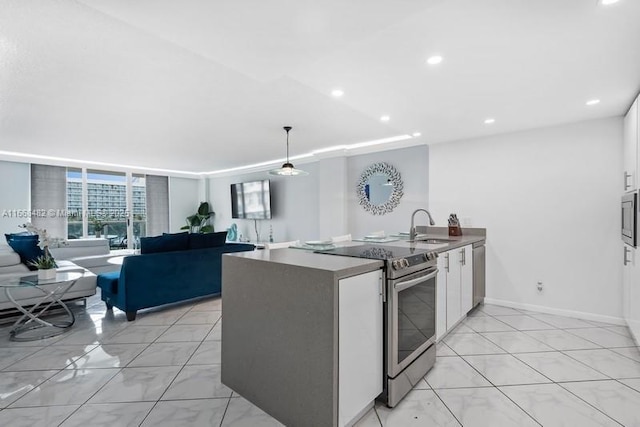 kitchen with open floor plan, stainless steel appliances, a sink, white cabinets, and a peninsula