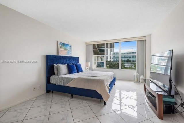 bedroom featuring marble finish floor