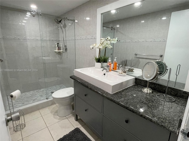 bathroom featuring tile walls, tile patterned flooring, an enclosed shower, vanity, and toilet