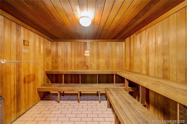 view of sauna with tile patterned floors, wood walls, and wooden ceiling