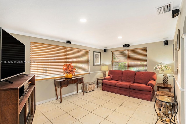 living room featuring ornamental molding and light tile patterned flooring