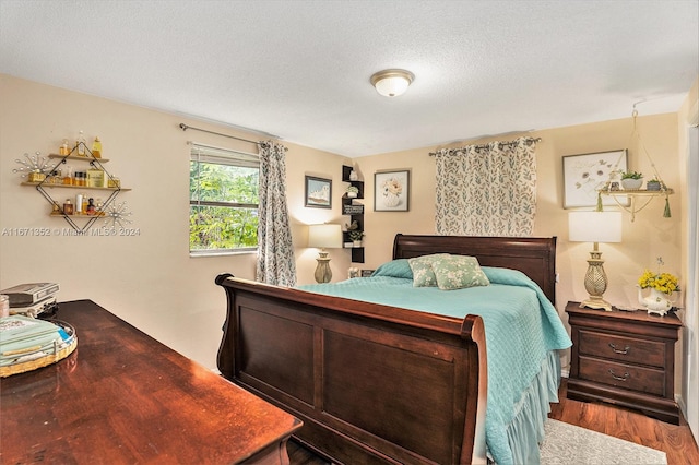 bedroom featuring wood-type flooring and a textured ceiling