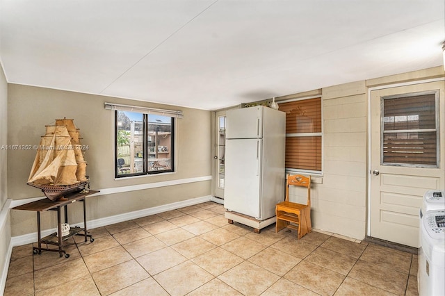 kitchen with light tile patterned floors and white refrigerator