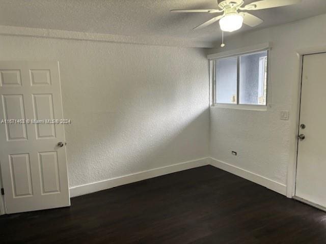 spare room featuring ceiling fan and dark wood-type flooring