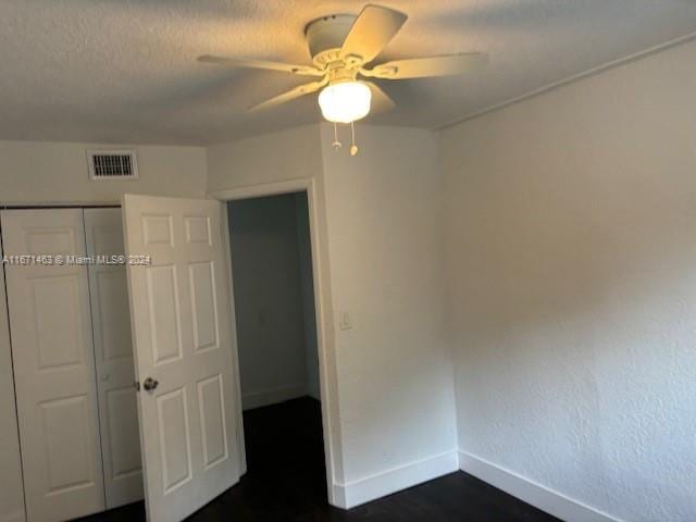 unfurnished bedroom with ceiling fan and a closet