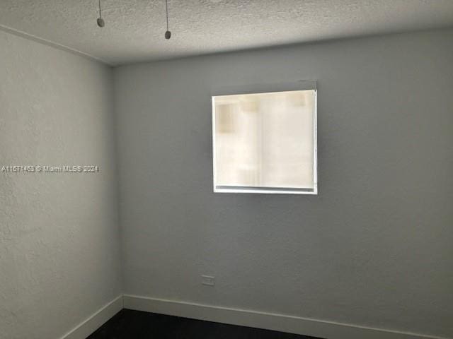 unfurnished room featuring a textured ceiling