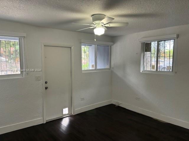 foyer entrance featuring a textured ceiling, dark hardwood / wood-style flooring, and ceiling fan