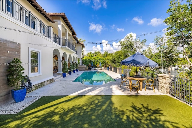 view of pool with a yard and a patio