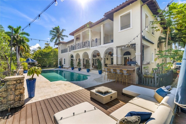 view of pool with outdoor lounge area, a bar, and a patio area