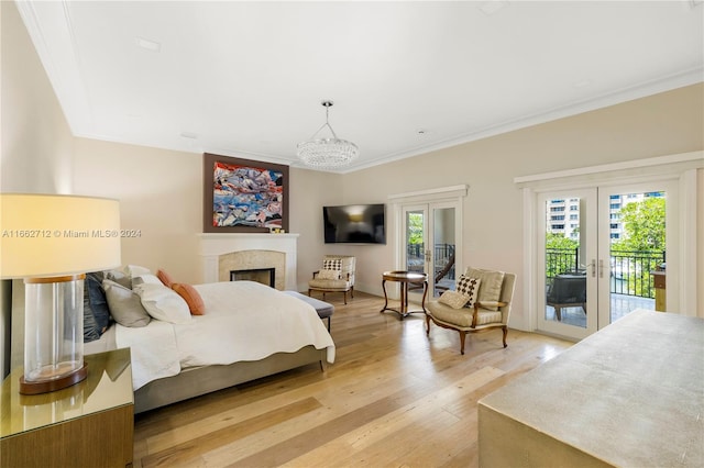 bedroom with french doors, access to outside, crown molding, light hardwood / wood-style flooring, and a notable chandelier