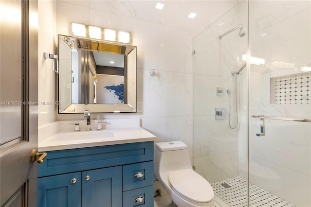 bathroom featuring vanity, toilet, tile walls, and a shower with shower door