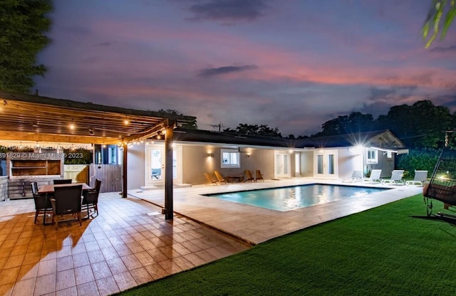 pool at dusk with a pergola and a patio area