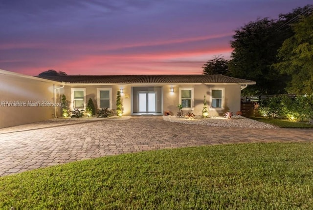 view of front facade featuring a lawn and french doors