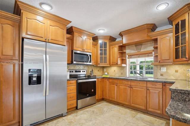 kitchen with glass insert cabinets, appliances with stainless steel finishes, open shelves, and a sink