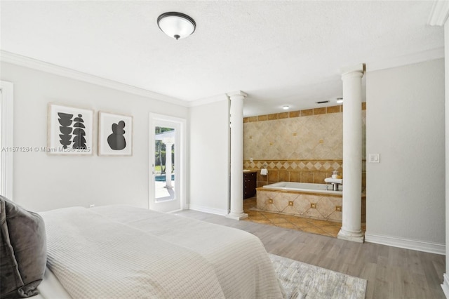 bedroom featuring crown molding, light wood-type flooring, connected bathroom, and ornate columns