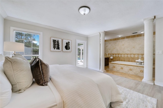 bedroom featuring decorative columns and crown molding