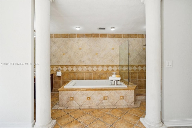 bathroom featuring a garden tub, decorative columns, visible vents, and tile patterned flooring