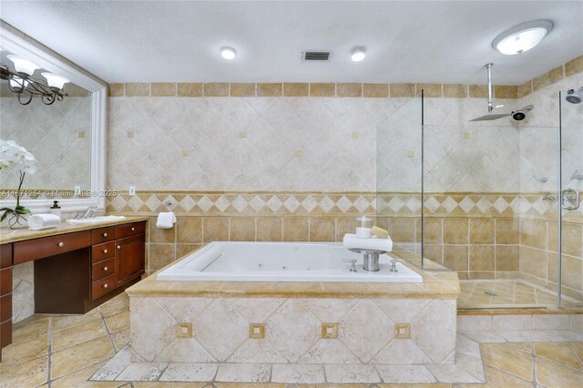 bathroom with tile walls, vanity, a textured ceiling, and separate shower and tub