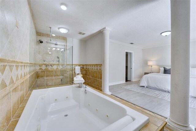 bathroom with tile walls, crown molding, ornate columns, and independent shower and bath