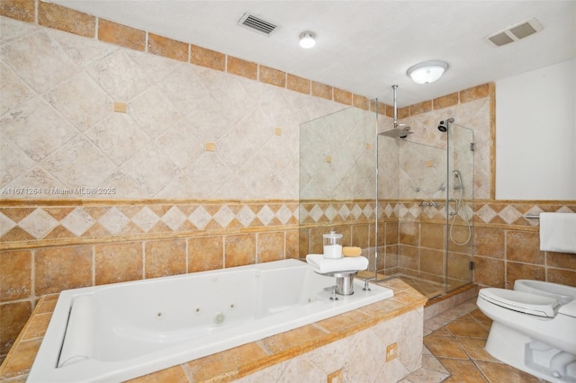 bathroom featuring tile patterned floors, toilet, shower with separate bathtub, and tile walls