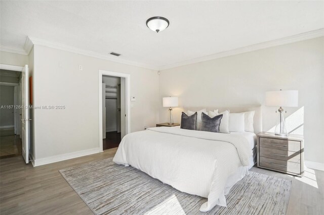 bedroom featuring hardwood / wood-style flooring and crown molding