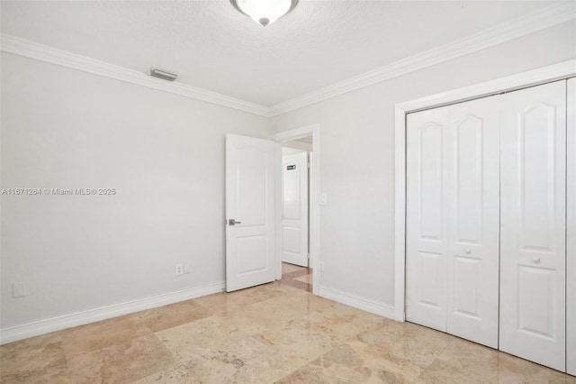 unfurnished bedroom featuring a closet, visible vents, ornamental molding, a textured ceiling, and baseboards