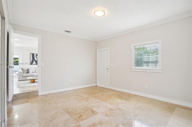 spare room featuring a wealth of natural light and crown molding