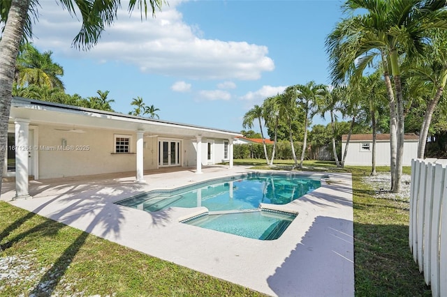 view of swimming pool featuring an in ground hot tub, french doors, a storage shed, and a patio