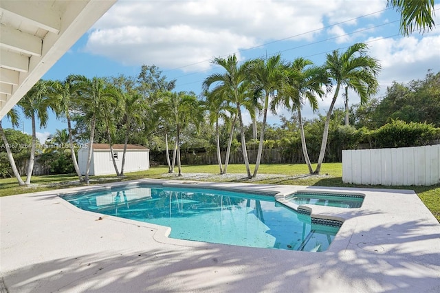 view of swimming pool with a storage shed, a fenced backyard, a pool with connected hot tub, and an outdoor structure