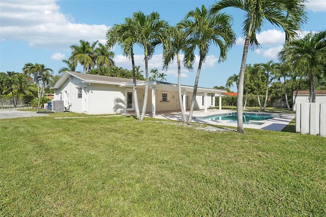 back of house with a fenced in pool, a yard, a patio, and stucco siding