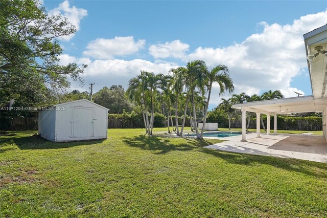 view of yard featuring a fenced in pool, a storage shed, and a patio